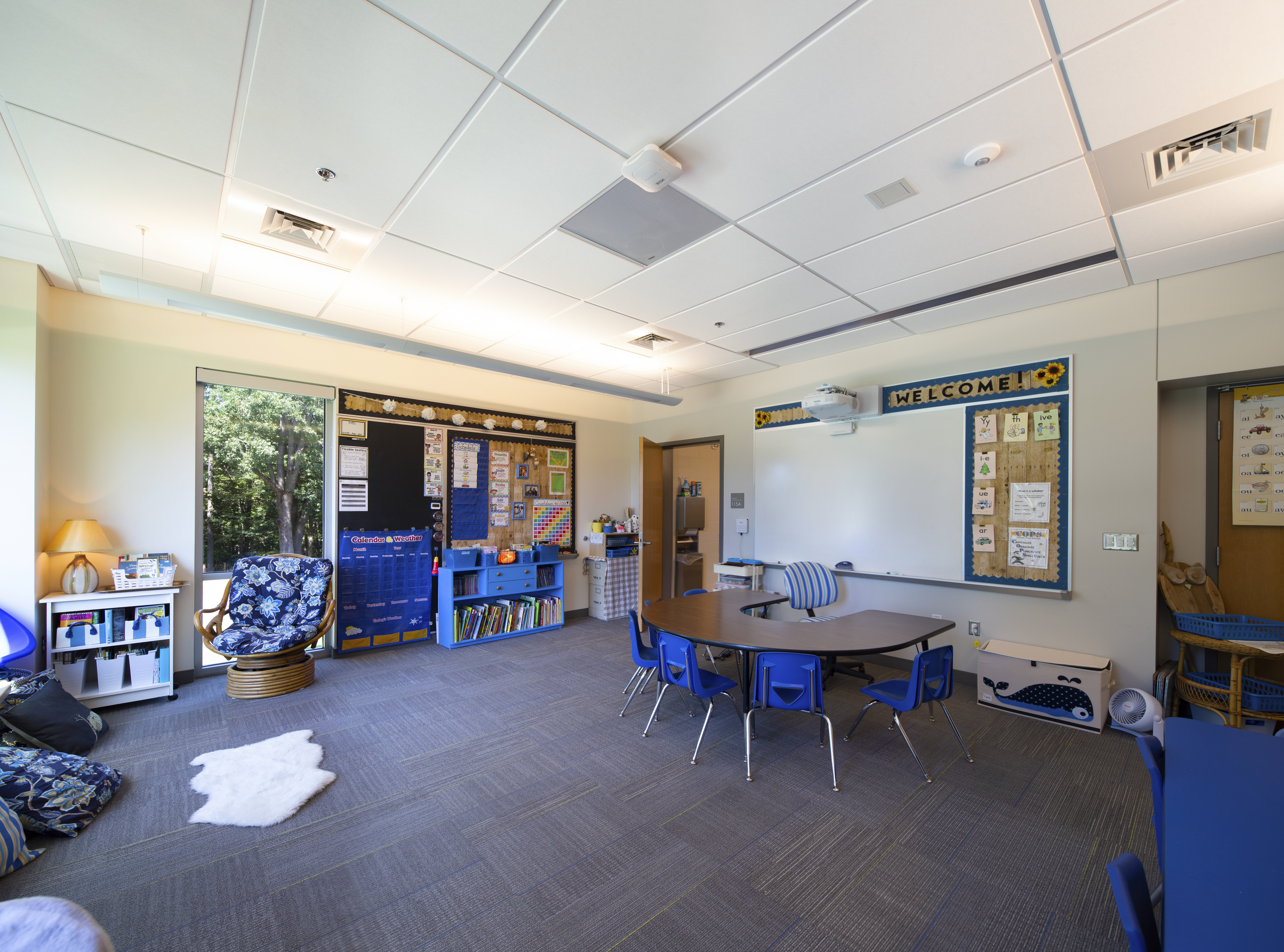 Decorated classroom with floor to ceiling windows and nature views  